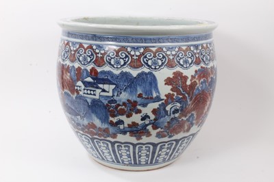 Lot 261 - Large Chinese porcelain fish bowl, 20th century, decorated in underglaze blue and red with landscape scenes and patterned borders