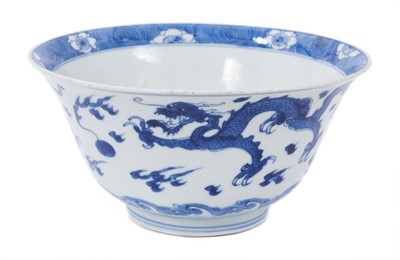 Lot 129 - Fine Chinese blue and white bowl, Kangxi period, of round form with straight foot and flared rim, decorated with dragons chasing flaming pearls, amongst stylised clouds and waves, prunus flowers on...