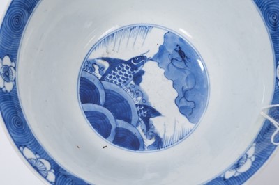 Lot 129 - Fine Chinese blue and white bowl, Kangxi period, of round form with straight foot and flared rim, decorated with dragons chasing flaming pearls, amongst stylised clouds and waves, prunus flowers on...