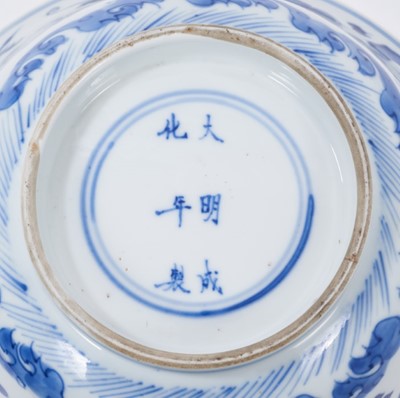 Lot 129 - Fine Chinese blue and white bowl, Kangxi period, of round form with straight foot and flared rim, decorated with dragons chasing flaming pearls, amongst stylised clouds and waves, prunus flowers on...