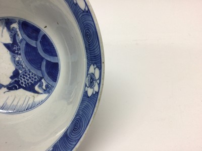 Lot 129 - Fine Chinese blue and white bowl, Kangxi period, of round form with straight foot and flared rim, decorated with dragons chasing flaming pearls, amongst stylised clouds and waves, prunus flowers on...