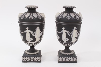 Lot 217 - A pair of Wedgwood black Jasperware urns, decorated in relief with classical figures, 19cm high