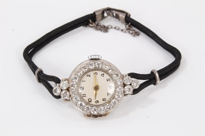 Lot 572 - 1920s ladies diamond and platinum cocktail wristwatch, the circular dial with diamond set bezel and shoulders, all with round old cut diamonds in millegrain setting in platinum case on black double...