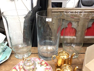 Lot 35 - Pair of large glass vases/storm lanterns, together with another large cylindrical vase (3)