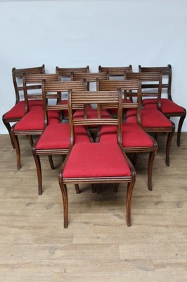 Lot 1466 - Set of twelve Regency mahogany dining chairs with reeded bar backs, drop-in seats, on sabre legs (one a copy)