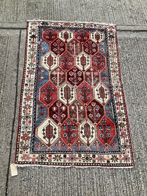 Lot 1121 - Eastern rug with geometric decoration on blue, red and cream ground, 203cm x 128cm
