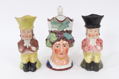 Lot 20 - Staffordshire Pearlware character jug, early 19th century, in the form of a woman with grapevines around her head, the scrollwork handle with lion-form terminal, 17cm high, together with two simila...