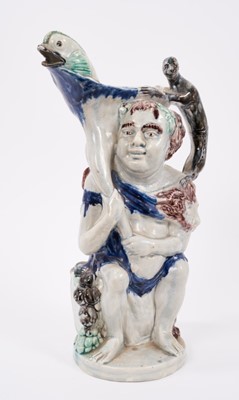 Lot 23 - Prattware 'Bacchus & Pan' jug, circa 1800, Bacchus shown seated on a barrel, with dolphin form spout and monkey handle, Pan to the reverse stood next to an owl, 34cm high