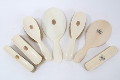 Lot 111 - Victorian five piece ivory dressing table set, comprising four brushes and a hand mirror, all with applied yellow metal cartouche engraved R, together with one other hand mirror and matching brush,...