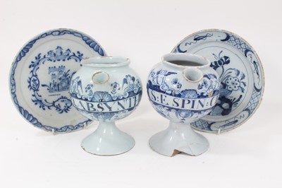 Lot 84 - Two 18th century English blue and white delft wet drug jars, of bulbous form, inscribed 'O.ABSYNTH' and 'S:E SPIN: CE' within cartouches supported by winged cherubs, 18.5cm high