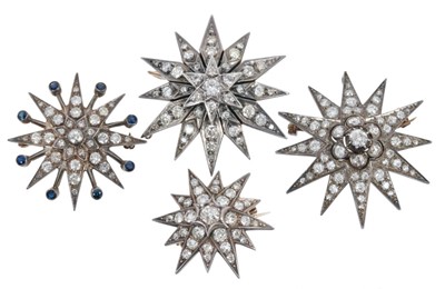 Lot 427 - Four diamond star brooches with old cut and brilliant cut diamonds in silver setting on gold, largest approximately 42mm.