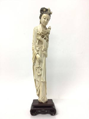 Lot 13 - Large 19th century Japanese ivory tusk figure of a woman, shown wearing a long robe and holding flowers, on a wooden base, total height 46cm