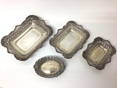 Lot 30 - Three silver graduated rectangular dishes with pierced and floral decoration and one other oval silver dish (4)