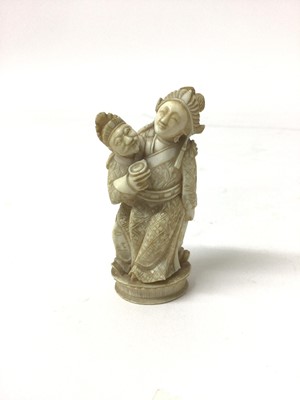 Lot 37 - 19th century carved ivory group, showing a woman seated on a man's lap, 6.5cm high
