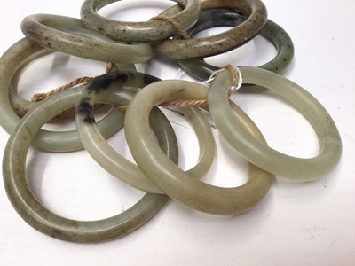 Lot 37 - Ten green jade/ hard stone polished bangles