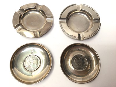 Lot 99 - Two silver pin dishes each set with a commemorative Churchill coin and Britannia coin, together with two silver ashtrays
