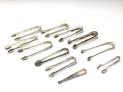 Lot 327 - Eleven pairs of Georgian and Victorian silver sugar tongs, most with bright cut engraved decoration, various dates and makers, all at approximately 10oz, (11)