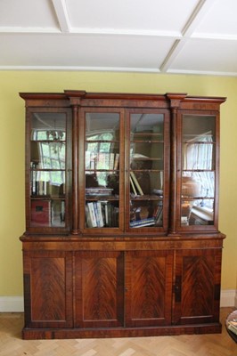 Lot 1202 - Good quality Regency flame mahogany two height breakfront bookcase with architectural pediment, the top with adjustable shelves enclosed by glazed doors with turned tulip head glazing bars, flanked...