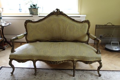 Lot 1203 - 19th century French giltwood sofa upholstered in gold damask with rococo scroll cresting, padded open arms and serpentine front on cabriole legs with scroll feet, 178cm.