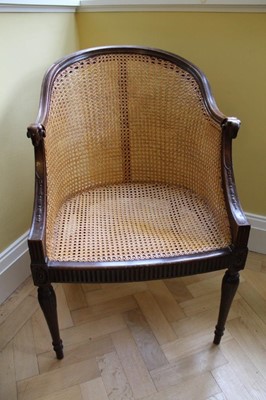 Lot 1206 - Edwardian neoclassical revival carved mahogany bergere tub chair with rams head terminals, carved husks, paterae and fluted frieze on carved and turned legs