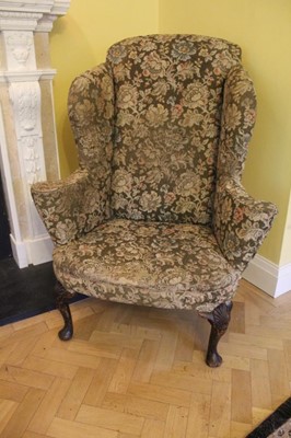 Lot 1212 - Good George I walnut wing back armchair with scroll arms on carved cabriole front supports with carved shell knees terminating on fad feet.