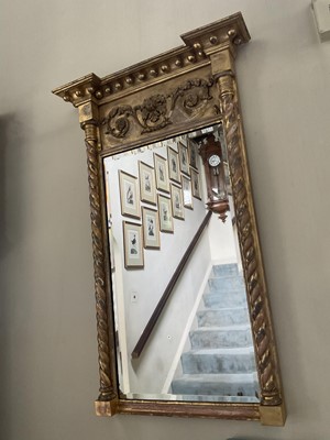 Lot 1235 - Regency gilt pier mirror, with ball mounted cornice and bevelled rectangular plate between projecting twist columns, 96 x 51cm
