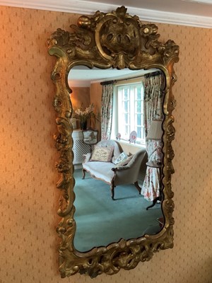 Lot 1238 - Early 18th century style pierced gilt gesso wall mirror, shaped plate within pieced c-scroll frame with foliate swags, 109 x 56cm