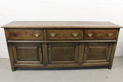 Lot 1289 - Mid 18th century oak dresser base, with three frieze drawers and fielded panel cupboard doors below on stiles, 190cm wide x 46cm deep x 81cm high