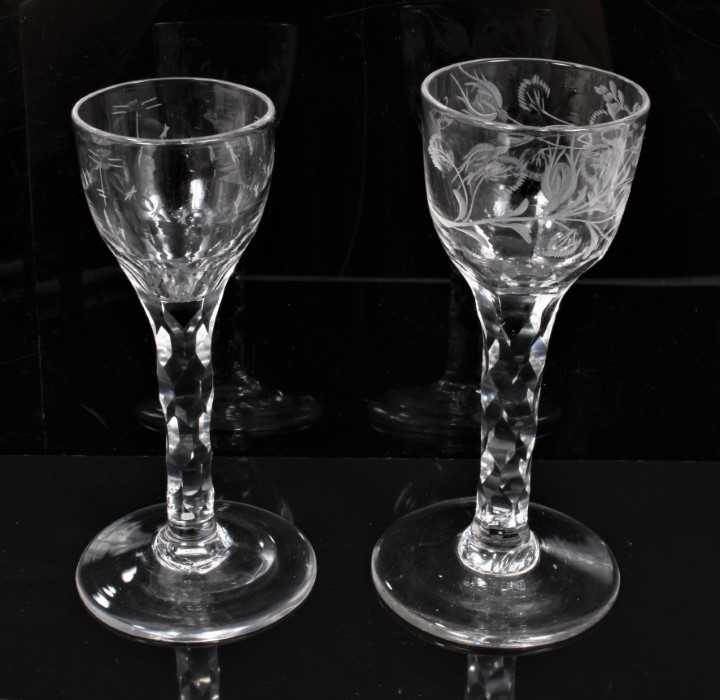 Lot 277 - Two Georgian wine glasses with floral and swag cut bowls on faceted stems on splayed foot 13.5-14 cm (2)