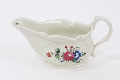 Lot 31 - A Pennington Liverpool cream boat, polychrome painted with floral sprays, with scrollwork moulding, 13cm from spout to handle