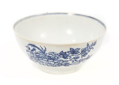 Lot 52 - A rare Isleworth blue and white porcelain bowl, circa 1770, transfer printed with a variation of the Fence pattern on one side, and another Oriental scene verso, with a cornucopia, two birds and a...