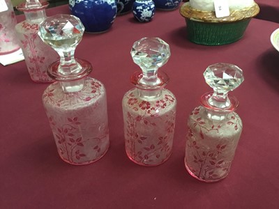 Lot 87 - Rare set of five early 20th century Baccarat crystal graduated scent bottles with facet cut stoppers and cylinderical body with cranberry overlaid faux cameo glass decoration depicting rose bushes...