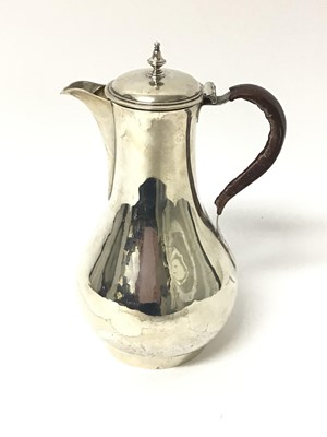 Lot 255 - George III silver jug of baluster form, with hinged cover and leather covered handle, on a circular base (London 1768) Philip Norman. All at approximately 13ozs. 23.5cm overall height.