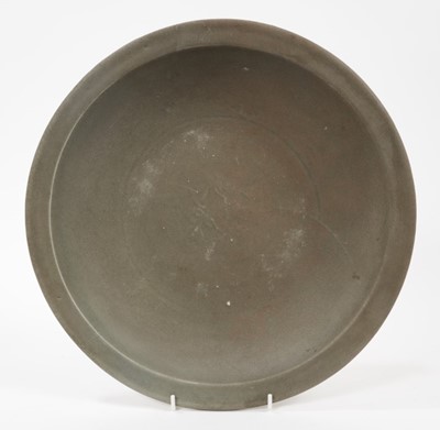 Lot 104 - Chinese celadon dish, Yuan dynasty, from the Java shipwreck, with floral moulding, 31cm diameter, together with a book on the Hatcher cargo (2)