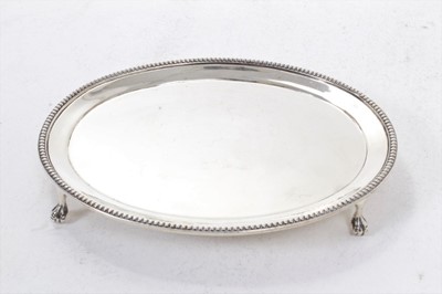 Lot 286 - Late Victorian silver card tray of oval form, with bead border, on four ball and claw feet