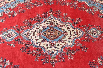 Lot 1488 - Large Persian carpet on red ground