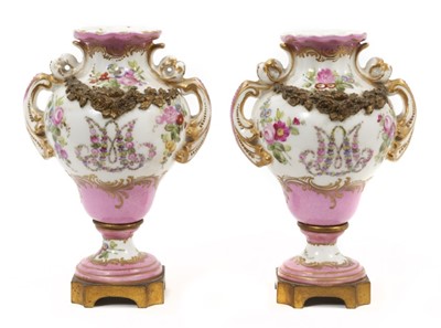 Lot 126 - A small pair of Sèvres ormolu-mounted porcelain urns, 19th century, decorated with floral sprays and swags, with rococo scrollwork, marks to bases, 13cm high