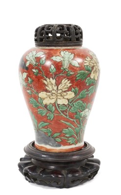Lot 150 - Chinese Wucai baluster jar, 17th century, decorated with a bird in flight amongst rockwork and flowers, with carved wooden stand and cover, 16cm high without stand and cover