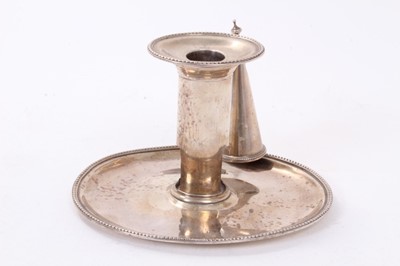 Lot 414 - George III silver chamberstick of oval form with beaded borders, removable snuffer and sconce, and engraved armorials, (London 1786), maker Thomas Chawner, all at 8ozs, 16cm in diameter.
