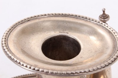 Lot 414 - George III silver chamberstick of oval form with beaded borders, removable snuffer and sconce, and engraved armorials, (London 1786), maker Thomas Chawner, all at 8ozs, 16cm in diameter.