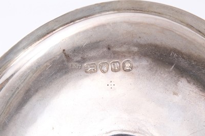 Lot 414 - George III silver chamberstick of oval form with beaded borders, removable snuffer and sconce, and engraved armorials, (London 1786), maker Thomas Chawner, all at 8ozs, 16cm in diameter.