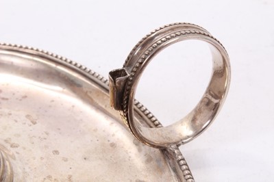 Lot 414 - George III silver chamberstick of oval form with beaded borders, removable snuffer and sconce, and engraved armorials, (London 1786), maker Thomas Chawner, all at 8ozs, 16cm in diameter.