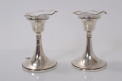 Lot 143 - Pair of George V silver dwarf candlesticks with flared central columns on circular bases, (Birmingham 1923), maker William Devenport, 11cm in overall height. (2)