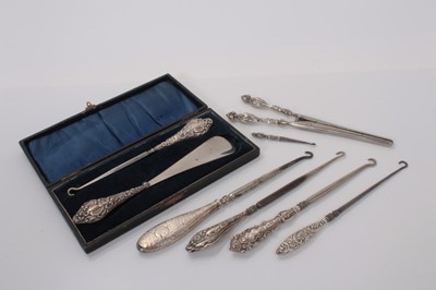 Lot 542 - Group of six silver handled button hooks, including one in a fitted case with a shoe horn and a pair of silver handled glove stretchers, (various dates and makers), (8)