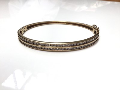 Lot 77 - 9ct gold bangle with two rows of synthetic white stones in channel setting
