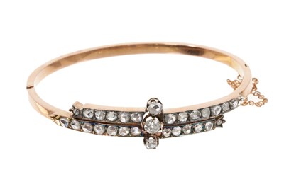 Lot 790 - Victorian diamond hinged bangle with a central old cut diamond flanked by two rose cut diamonds on a double row of further old cut diamonds in a cross-over design in silver and rose gold setting.