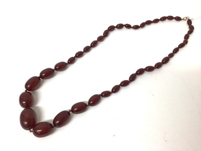 Lot 106 - Simulated cherry amber necklace with graduating polished oval beads, 77cm long