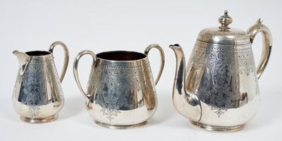 Lot 368 - Victorian silver three piece teaset comprising teapot of tapered cylindrical form with overall engraved foliate and scroll decoration and handle with ivory insulators.