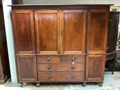 Lot 1327 - 19th century mahogany compactum wardrobe with central chest of four drawers, 
press above, flanked by hanging spaces on turned feet.