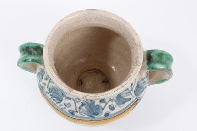 Lot 27 - An unusual Italian maiolica twin-handled pot, with blank scrollwork cartouche, probably an apothecary jar, 11cm high